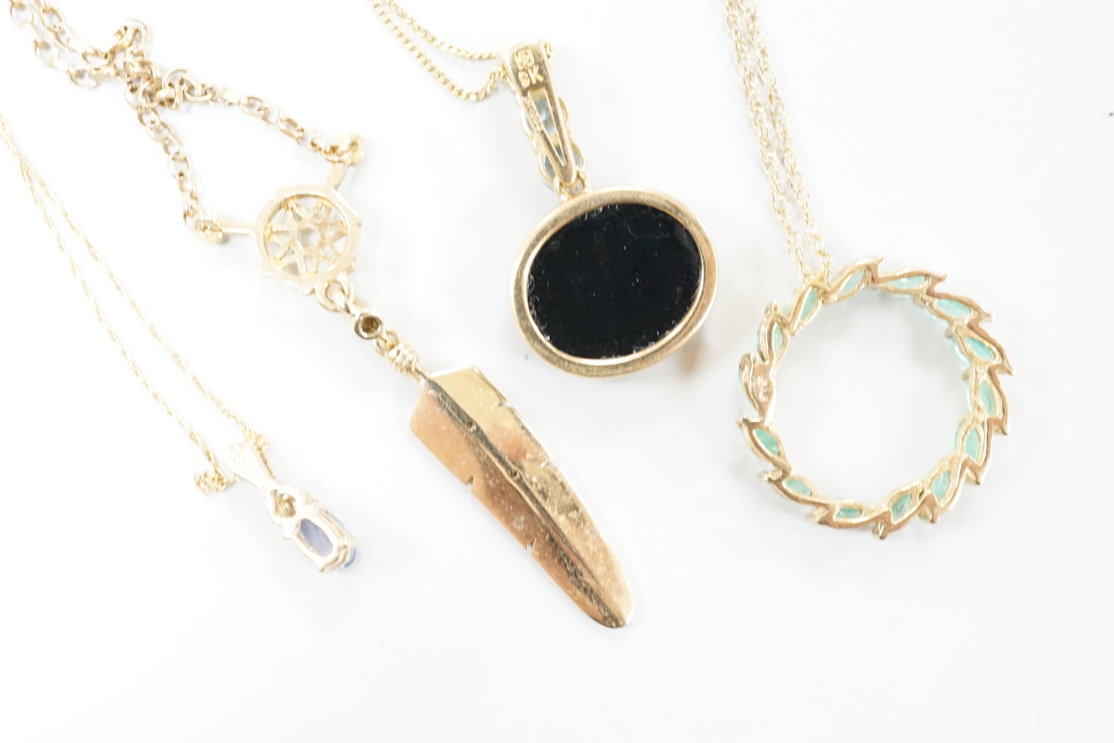 Three assorted modern 9ct or yellow metal and gem set pendants, on 9ct chains including opal doublet and blue topaz, feather shape and emerald set circular and a similar 10k pendant, on a 10k chain, longest 52cm, gross w